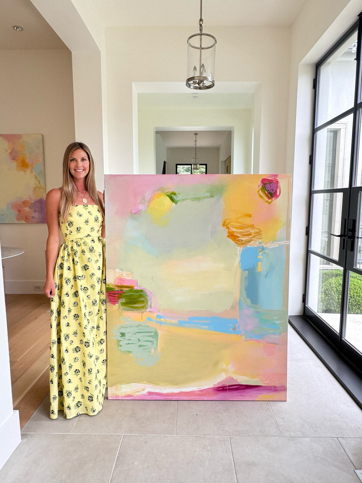 Chrissy Collins beside one of her large abstract paintings